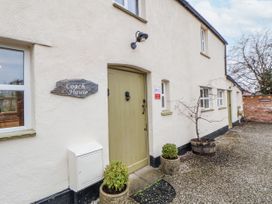 An entrance with a door and sign at The Coach House in Prestatyn
