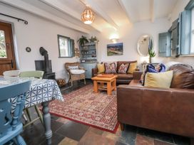 A living room with a sofa, coffee table, and wood stove at The Coach House in Prestatyn