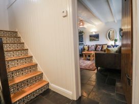 A hallway with stairs leading to a living room at The Coach House in Prestatyn