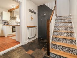 A hallway with staircase and kitchen entrance at The Coach House in Prestatyn