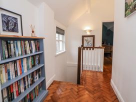 A hallway with a bookshelf and staircase at The Coach House in Prestatyn