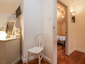 A bedroom with a chair and a mirror at The Coach House in Prestatyn
