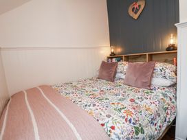 A bedroom with a floral bedspread and lamps at The Coach House in Prestatyn