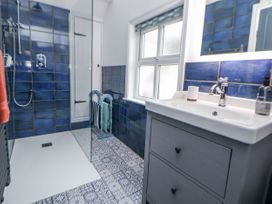 A bathroom with a shower and vanity unit at The Coach House in Prestatyn