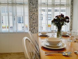 A dining room with a table set for a meal at Crab Cottage in Ilfracombe