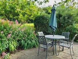 A garden with a table and chairs under an umbrella at Crab Cottage in Ilfracombe
