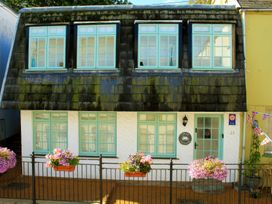 A house with multiple windows and flowers outside at Crab Cottage in Ilfracombe