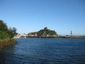 A view of a pier and buildings near the water at Crab Cottage in Ilfracombe