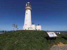 A lighthouse with road signs and a display sign at Apt 1 @ Hunter's Quay Bridlington
