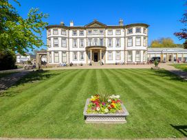 An outdoor area with a building and flower beds at Apt 1 @ Hunter's Quay Bridlington