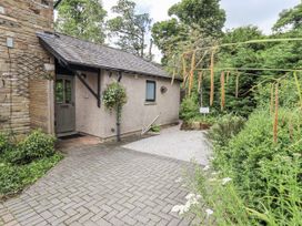 An entrance with a gravel path and a flower pot at Doe Foot Cottage Ingleton