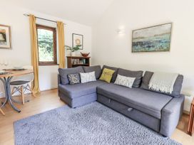 A living room with a sofa and dining table at Doe Foot Cottage in Ingleton