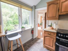 A kitchen with a window, countertop, and cooker at Doe Foot Cottage Ingleton