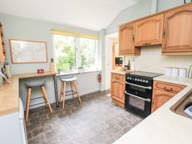 A kitchen with an oven and bar stools at Doe Foot Cottage Ingleton