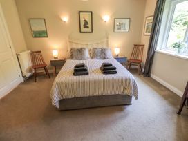 A bedroom with a bed and chairs at Doe Foot Cottage Ingleton