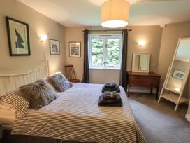A bedroom with a bed and a table at Doe Foot Cottage Ingleton