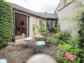 A garden with chairs and a table at Doe Foot Cottage in Ingleton