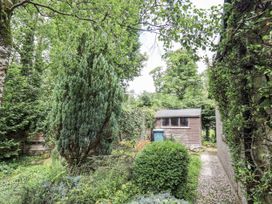 A garden with a shed and greenery at Doe Foot Cottage Ingleton