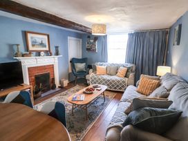 A living room with a sofa and armchair at Delphinium in Blakeney, Norfolk