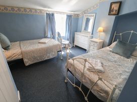 A bedroom with two beds and a dresser at Delphinium, Blakeney, Norfolk