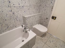A bathroom with a bathtub and toilet at Delphinium in Blakeney, Norfolk