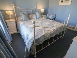 A bedroom with a bed and nightstand at Delphinium in Blakeney, Norfolk