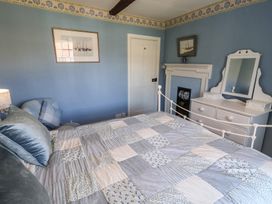 A bedroom with a bed and furniture at Delphinium in Blakeney, Norfolk