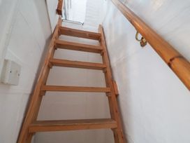 A staircase with wooden steps and a handrail at Delphinium in Blakeney, Norfolk