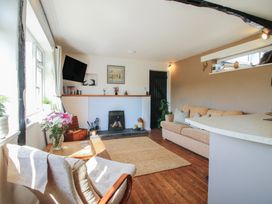 A living room with a beige sofa chair a television and a fireplace at The Old Beams at Pont y Forwyn in Llansantffraidd-ym-Mechain near Welshpool