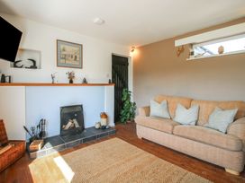 A living room with a sofa a fireplace and a rug at The Old Beams at Pont y Forwyn in Llansantffraidd-ym-Mechain near Welshpool