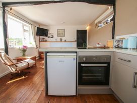 A kitchen with a refrigerator oven chair and flowers by a window at The Old Beams at Pont y Forwyn Llansantffraidd-ym-Mechain near Welshpool