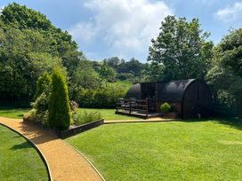 A cabin with a deck and chairs in a garden at Idris Pod St Asaph
