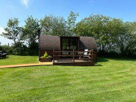 A wooden pod with decking and furniture at Gelert Pod St Asaph
