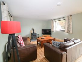 A living room with a fireplace and television at The Owl's Hoot in Tacumshane, County Wexford