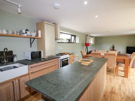 A kitchen with sink and dining table at The Owl's Hoot in Tacumshane, County Wexford