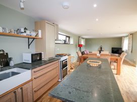 A kitchen with sink, stove, and dining area at The Owl's Hoot in Tacumshane, County Wexford