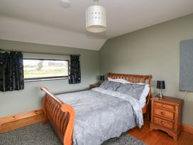 A bedroom with a bed and nightstand at The Owl's Hoot in Tacumshane, County Wexford