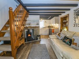 A living room with a staircase and a fireplace at The Cottage in Marian-Glas