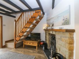 A living room with a staircase and television at The Cottage in Marian-Glas