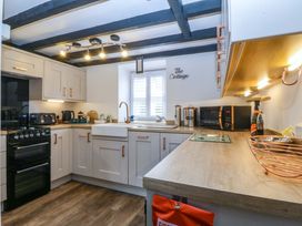 A kitchen with cabinets and appliances at The Cottage in Marian-Glas