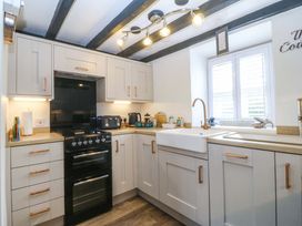 A kitchen with cabinets and an oven at The Cottage in Marian-Glas