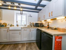 A kitchen with cabinets and appliances at The Cottage Marian-Glas