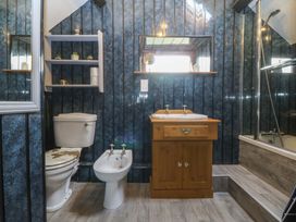 A bathroom with a toilet, bidet, sink, and shower at The Cottage in Marian-Glas