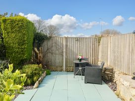 A garden with a table and chairs at The Cottage Marian-Glas