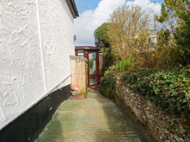 A garden path leading to a door with plants at The Cottage in Marian-Glas