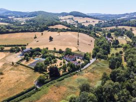 An outdoor area with a house, pool, and fields at Lower Tundridge Cottage in Suckley near Malvern