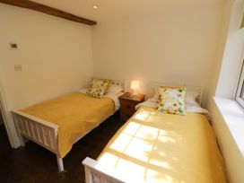 A bedroom with two beds and a lamp at Lower Tundridge Cottage Suckley near Malvern