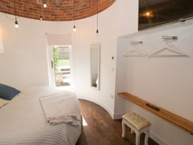 A bedroom with a bed and a mirror at Lower Tundridge Cottage Suckley near Malvern