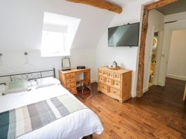 A bedroom with a bed, television, and a desk at Lower Tundridge Cottage Suckley near Malvern