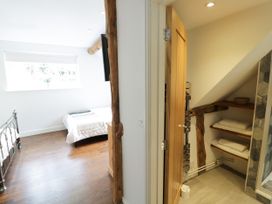 A bedroom with a bed and a door leading to a bathroom at Lower Tundridge Cottage Suckley near Malvern